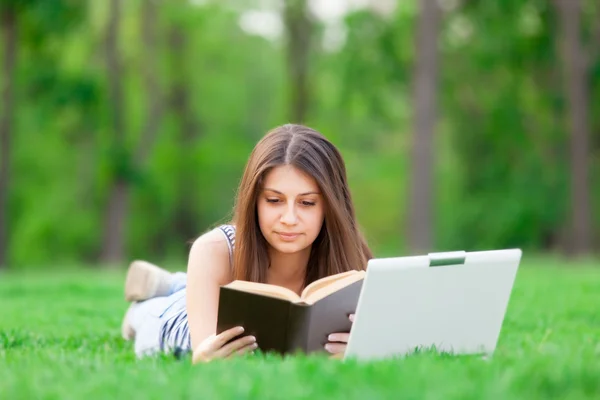 Chica con ordenador portátil y libro — Foto de Stock