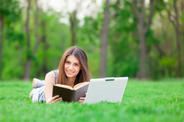 Chica con ordenador portátil y libro —  Fotos de Stock