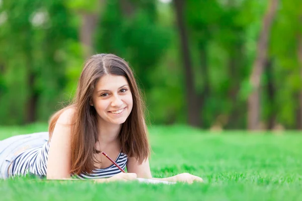 Menina com livro na grama verde — Fotografia de Stock