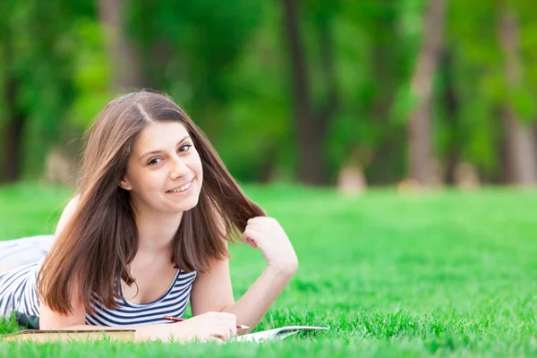 Menina com livro na grama verde — Fotografia de Stock