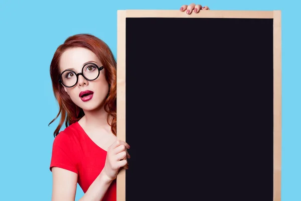 Girl in red dress with blackboard — Stock Photo, Image