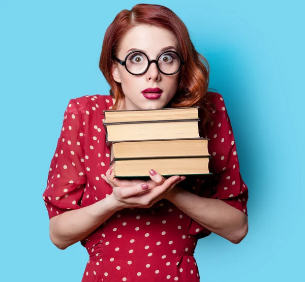 Meisje in een rode jurk met boeken — Stockfoto