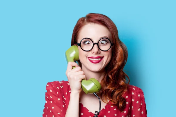 Menina em vestido vermelho com telefone mostrador verde — Fotografia de Stock