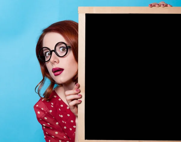 Meisje in een rode jurk met blackboard — Stockfoto