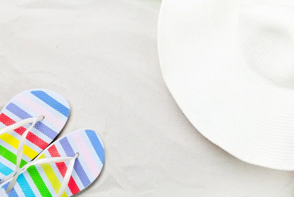Chinelos coloridos e chapéu de praia — Fotografia de Stock