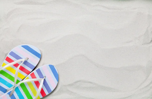 Colorful summer flip flops on white sand. — Stock Photo, Image