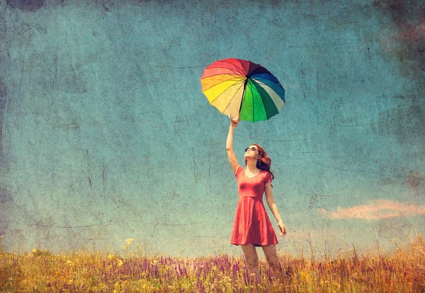 Woman in red dress with umbrella on meadow — Stock Photo, Image