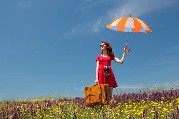 Şemsiye ve bavul ile Kırmızı elbiseli kadın — Stok fotoğraf