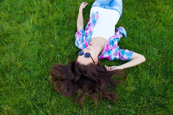 Woman lying down on green grass — Stock Photo, Image