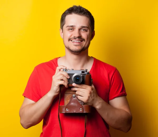 Guy in t-shirt with retro camera — Zdjęcie stockowe