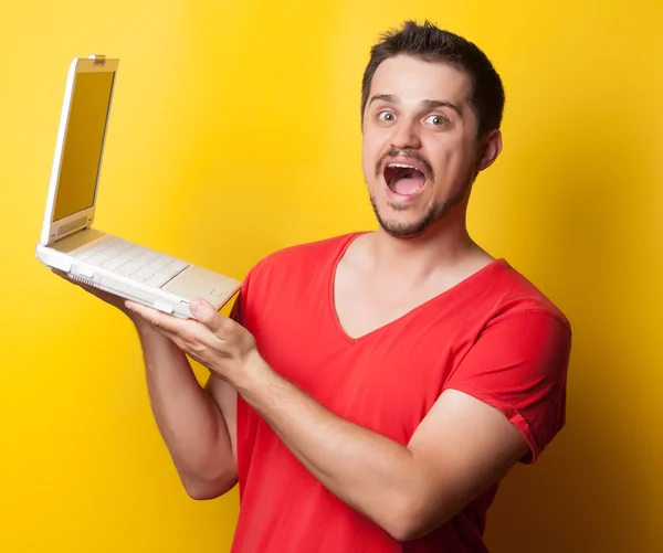 Guy in t-shirt with laptop computer — Stockfoto