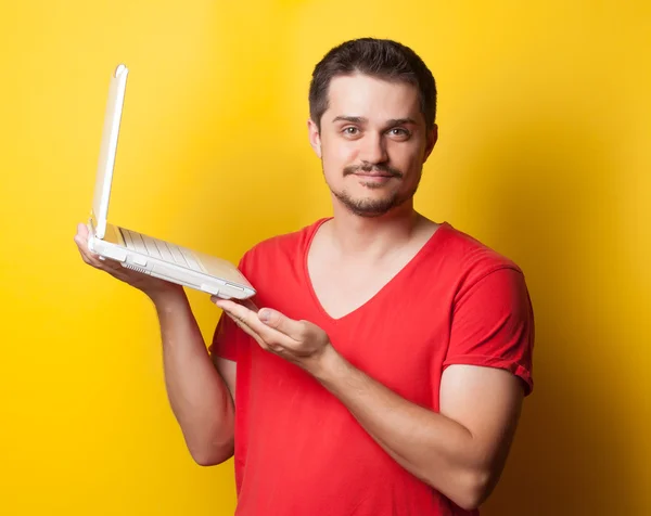 Guy in t-shirt with laptop computer — Stockfoto