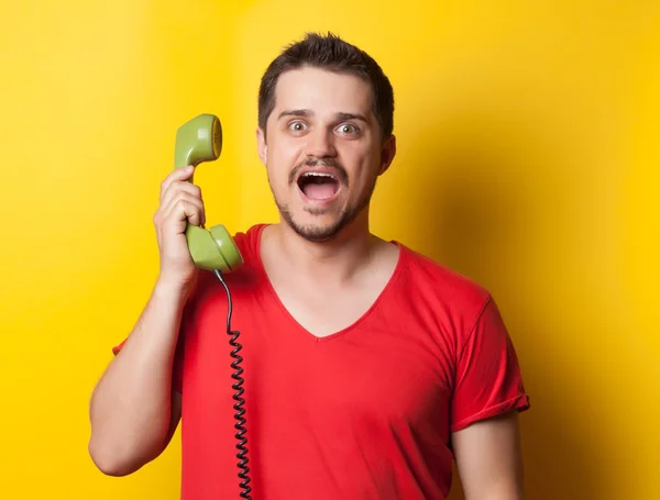 Guy in t-shirt with green retro phone — 스톡 사진