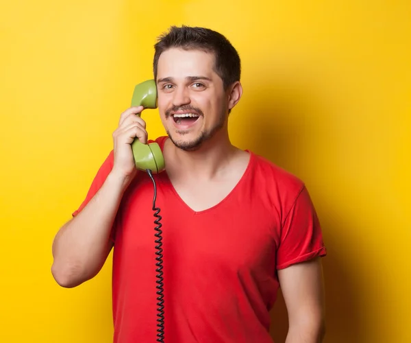 Guy in t-shirt with green retro phone — Stok fotoğraf