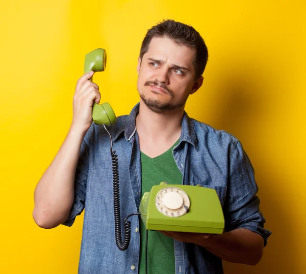 Хлопець у футболці з зеленим ретро телефоном — стокове фото