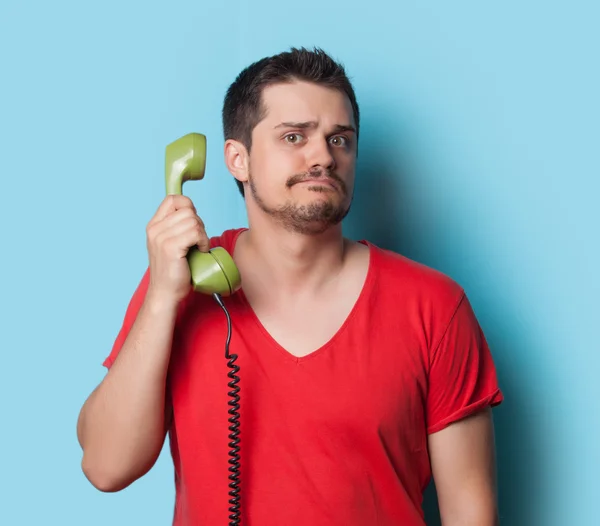 Guy in t-shirt with green retro phone — Stockfoto