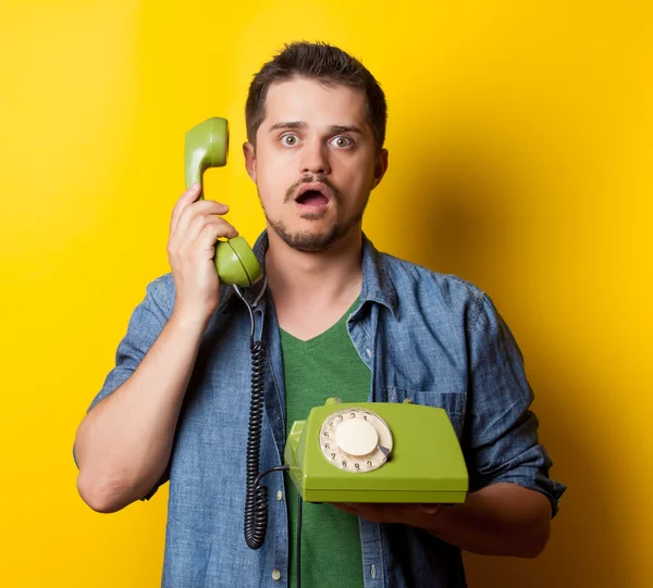 Guy in t-shirt with green retro phone — 图库照片
