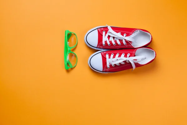 Eyeglasses and red gumshoes — Stock Photo, Image