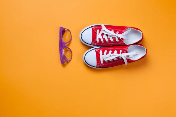 Eyeglasses and red gumshoes — Stock Photo, Image