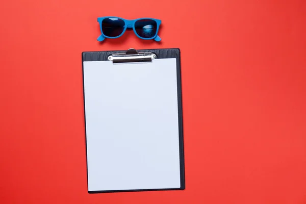 Clipboard with blank white paper and sunglasses — Stock Photo, Image