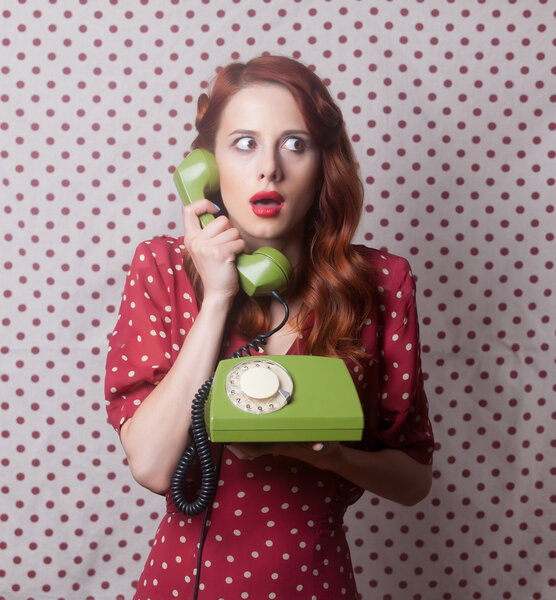 Портрет рыжеволосой женщины с зеленым телефоном
