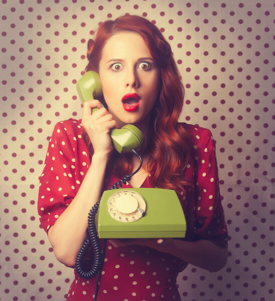 Портрет рыжеволосой женщины с зеленым телефоном

