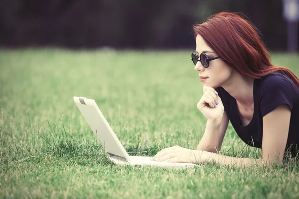 Femme rousse sur prairie avec ordinateur portable — Photo