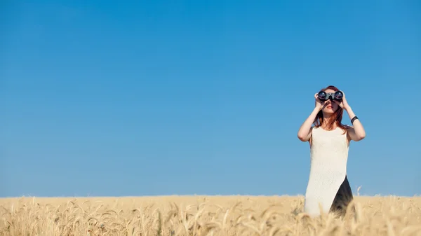 Fille avec binoculaire au champ de blé . — Photo