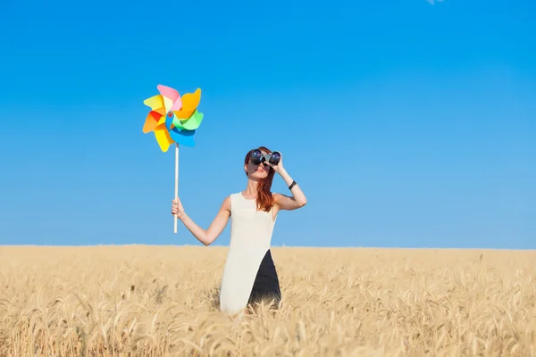 Girl in white dress with binocular and wind toy — 스톡 사진