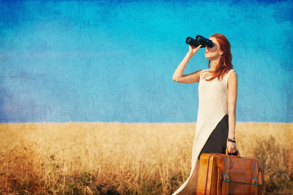 Girl with suitcase and binocular at countryside road — Stock Photo, Image