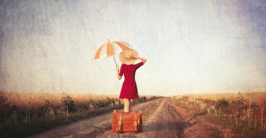 Bavul ve şemsiye ile Kızıl saçlı kız 