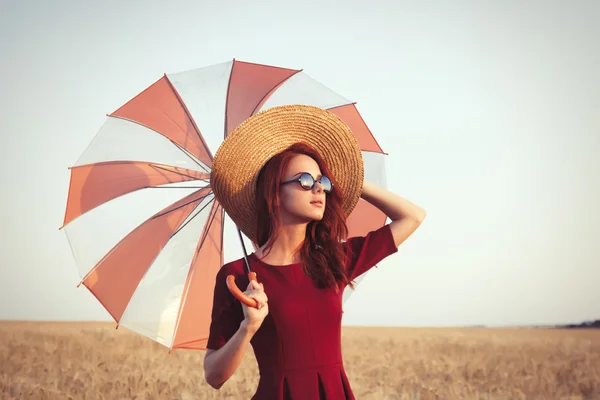 Menina em vestido vermelho com guarda-chuva e chapéu — Fotografia de Stock