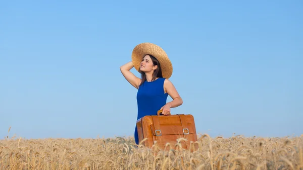 Chica con maleta en el campo de trigo — Foto de Stock