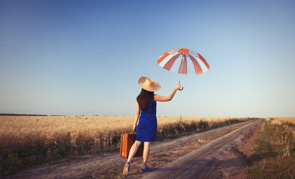 Dívka s kufrem a deštníkem — Stock fotografie