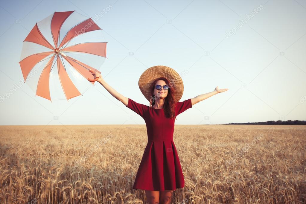 Girl in red dress with umbrella and hat 
