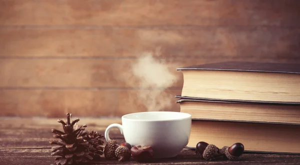 Cup of coffee and pine cone with books — Stock Photo, Image