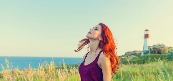 Girl near Lighthouse and blue sea — Stock Photo, Image