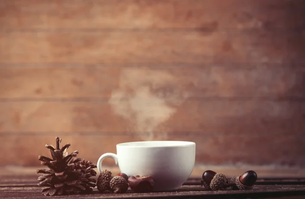 Kopp kaffe och tall kon med ekollon — Stockfoto