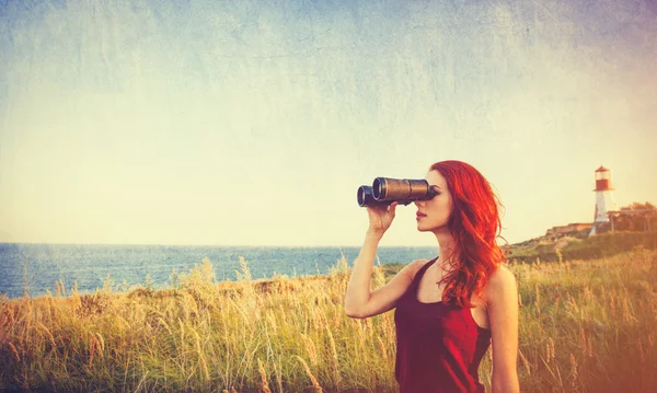 Menina com binocular perto do farol — Fotografia de Stock