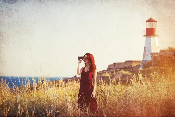 Ragazza con binocolo vicino al faro — Foto Stock