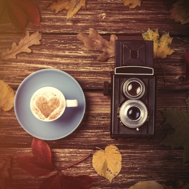 Sonbaharda yapraklar, fotoğraf makinesi ve kahve Kupası