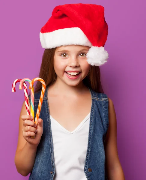 Chica en rojo Santas sombrero con caramelo —  Fotos de Stock