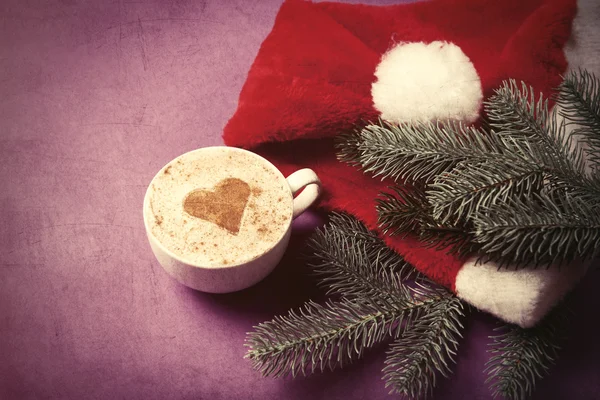 Cup of coffee and fir-tree branch with Santas — Stock Photo, Image