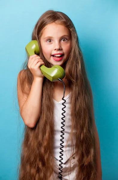 Молода усміхнена дівчина з зеленим телефоном — стокове фото