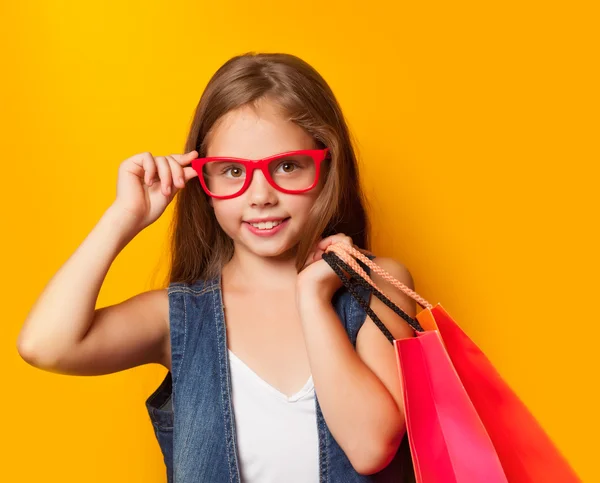 Girl in red glasses with shopping bag — Stock Photo, Image