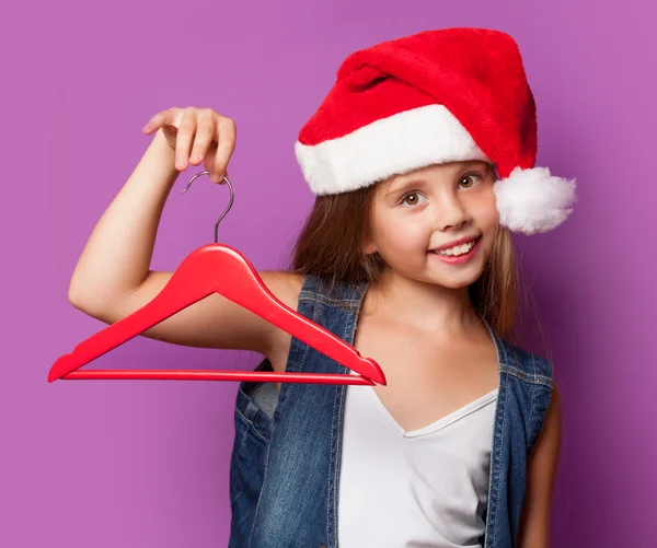 Girl in red Santas hat with hanger — Stock Photo, Image