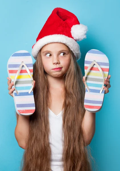 Menina em chapéu de Santas com chinelos — Fotografia de Stock