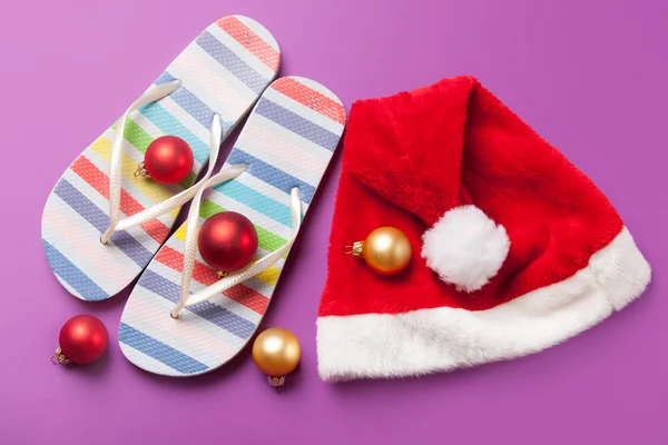 Santas hat and flip flops with christmas bubbles — Stock Photo, Image