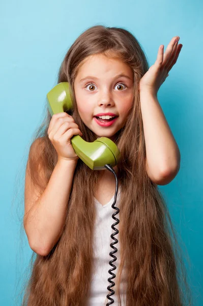 Молода усміхнена дівчина з зеленим телефоном — стокове фото