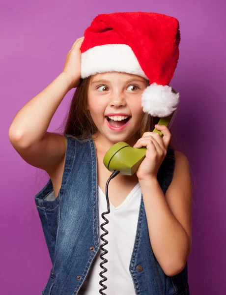 Niña en sombrero de Santas rojo con auricular verde —  Fotos de Stock